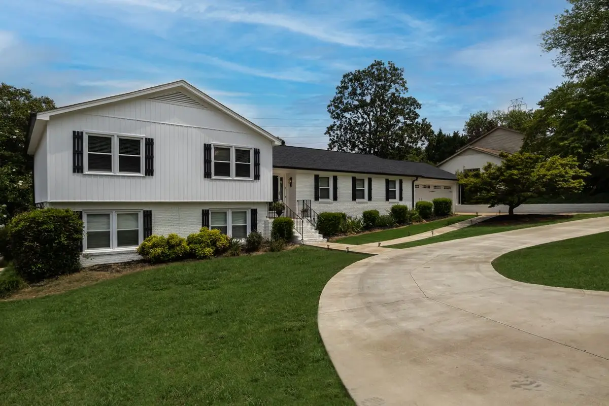 Wide concrete driveway curving up to a suburban home