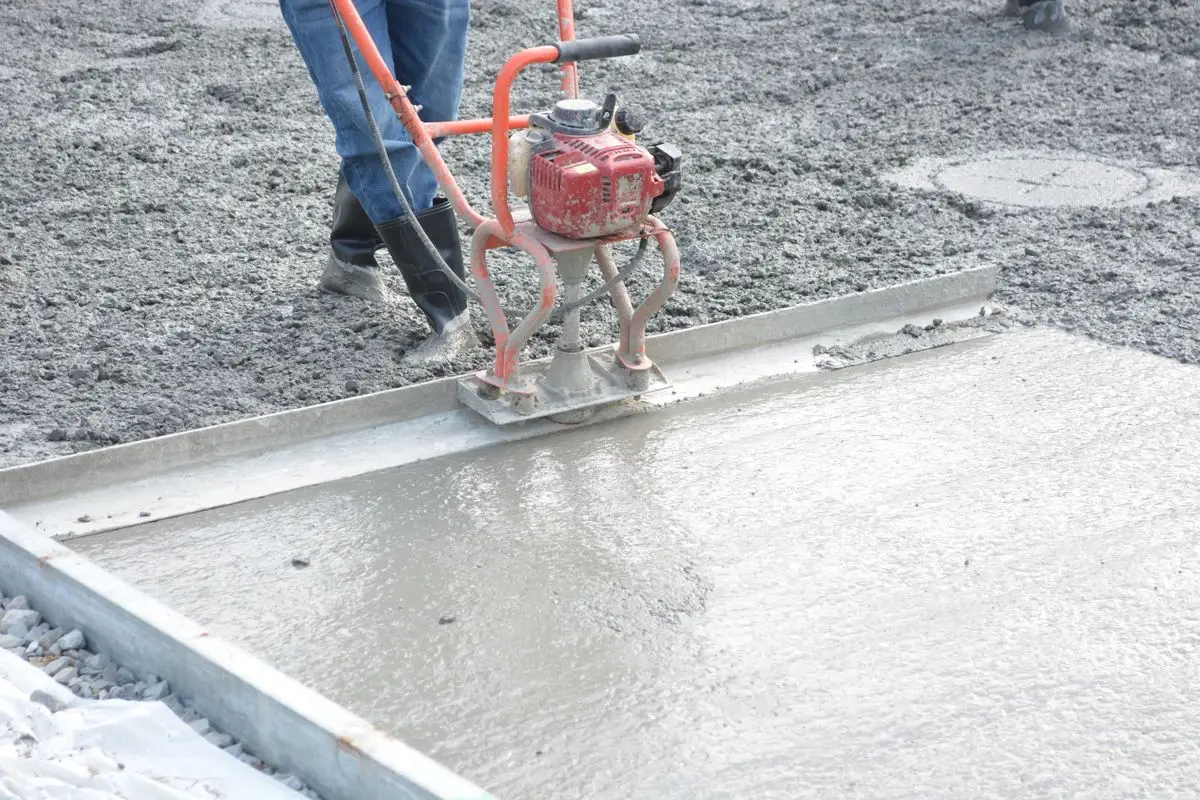 Power trowel smoothing freshly poured concrete