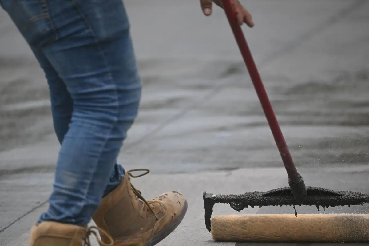 Sealer being rolled onto a concrete surface